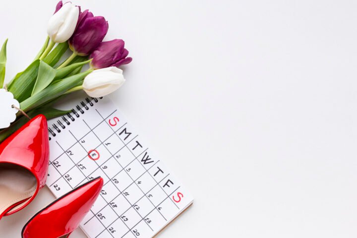 Photo of a red high heels, tulips and a calendar with the date 8 circled in red pencil.