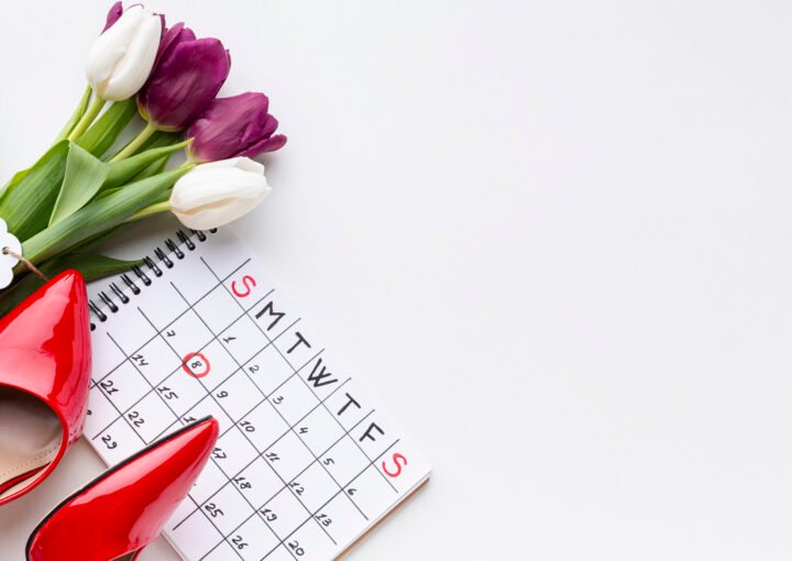Photo of a red high heels, tulips and a calendar with the date 8 circled in red pencil.